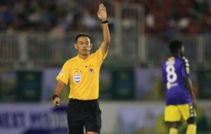 Trọng tài thổi còi và giơ tay lên